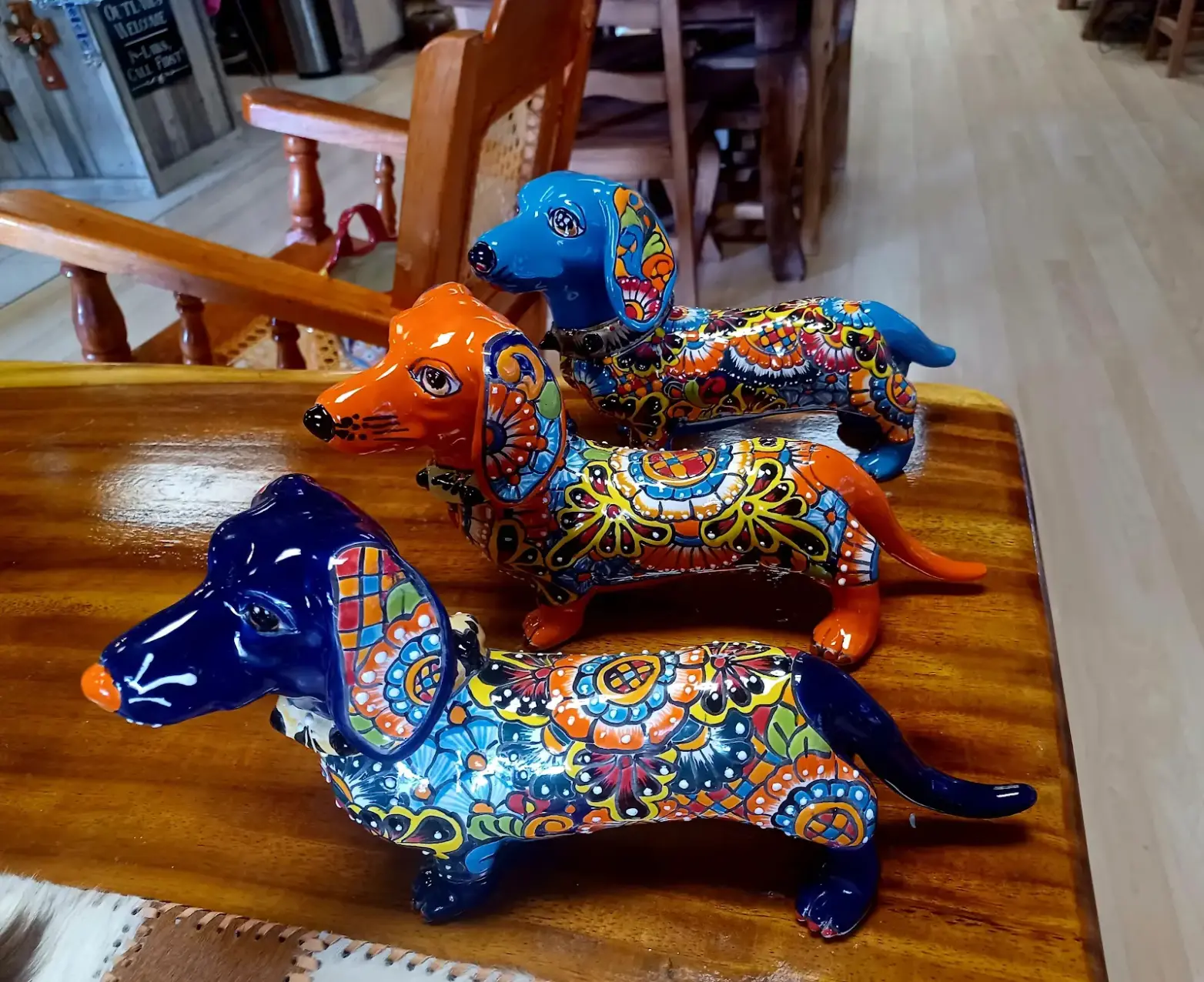 A row of ceramic dogs painted orange and blue
