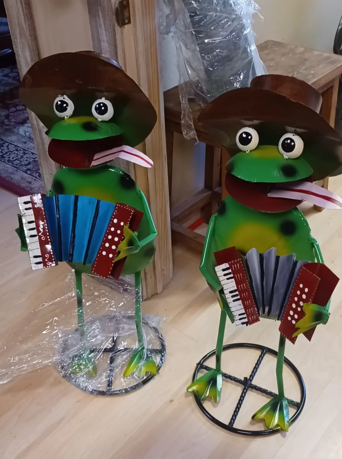 A pair of handmade metal frogs playing accordians
