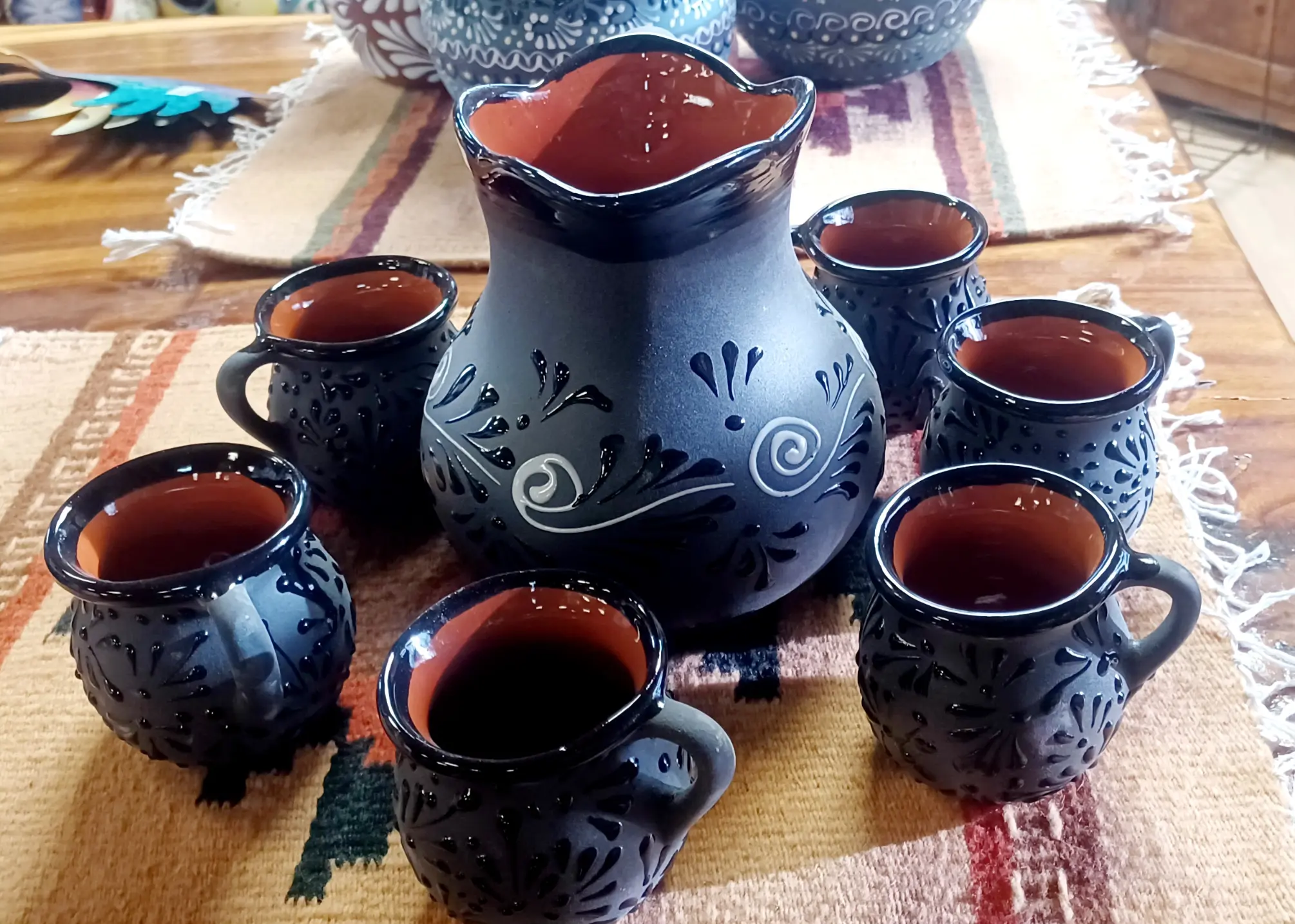 A black teapot with six matching cups